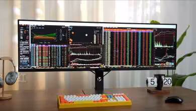 Moniteur ultrawide sur bureau avec graphiques boursiers éclairage naturel, fond flou