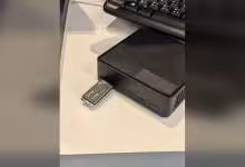 Lexar AI-Grade Storage Stick branché dans un mini-PC noir, avec clavier en arrière-plan