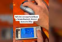 Main utilisant Nokia N95 avec Half-Life 1, souris visible, contraste fort sur fond orange