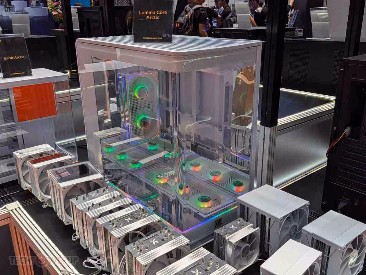 XIGMATEK Lumina Core et Aurora Core, deux designs atypiques vus au Computex 2026 2 Boîtier XIGMATEK Lumina Core Arctic transparent avec ventilateurs RGB et plusieurs boîtiers compacts exposés devant