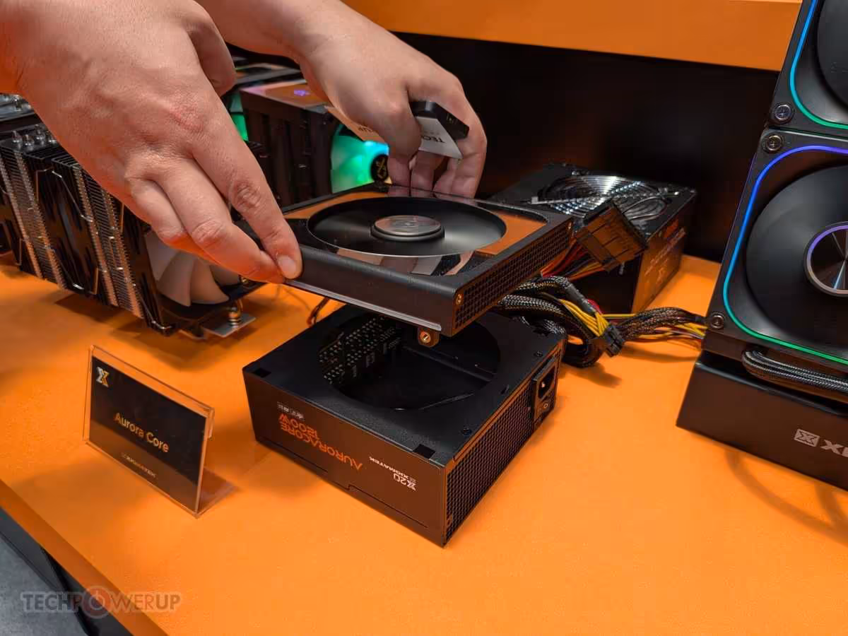XIGMATEK Lumina Core et Aurora Core, deux designs atypiques vus au Computex 2026 4 Main installant un ventilateur sur un boîtier XIGMATEK Aurora Core, avec alimentation et câbles visibles