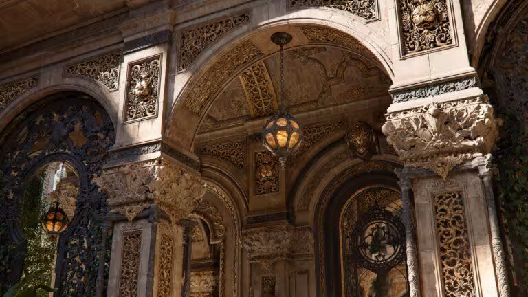 Vestibule d'architecture ancienne avec arcs ornés et lampes suspendues, détails sculptés en relief