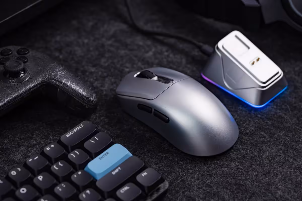 Souris gaming grise avec clavier mécanique RGB et accessoire blanc lumineux, sur fond noir