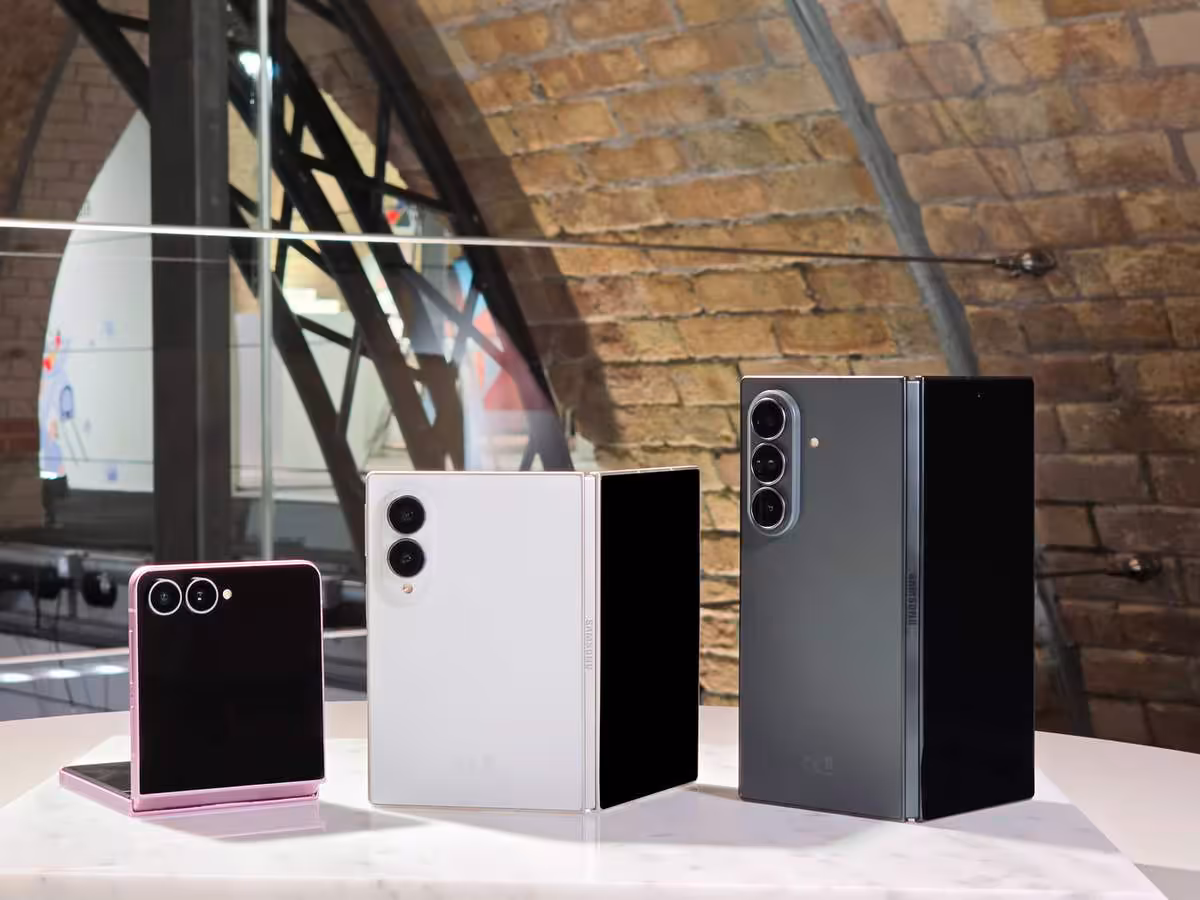 Galaxy Z Fold8, Fold8 et Flip8 exposés sur une table dans un décor industriel en briques