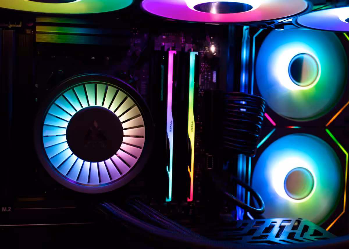 Gros plan intérieur d’un PC gamer RGB avec ventilateurs lumineux, RAM RGB et carte graphique