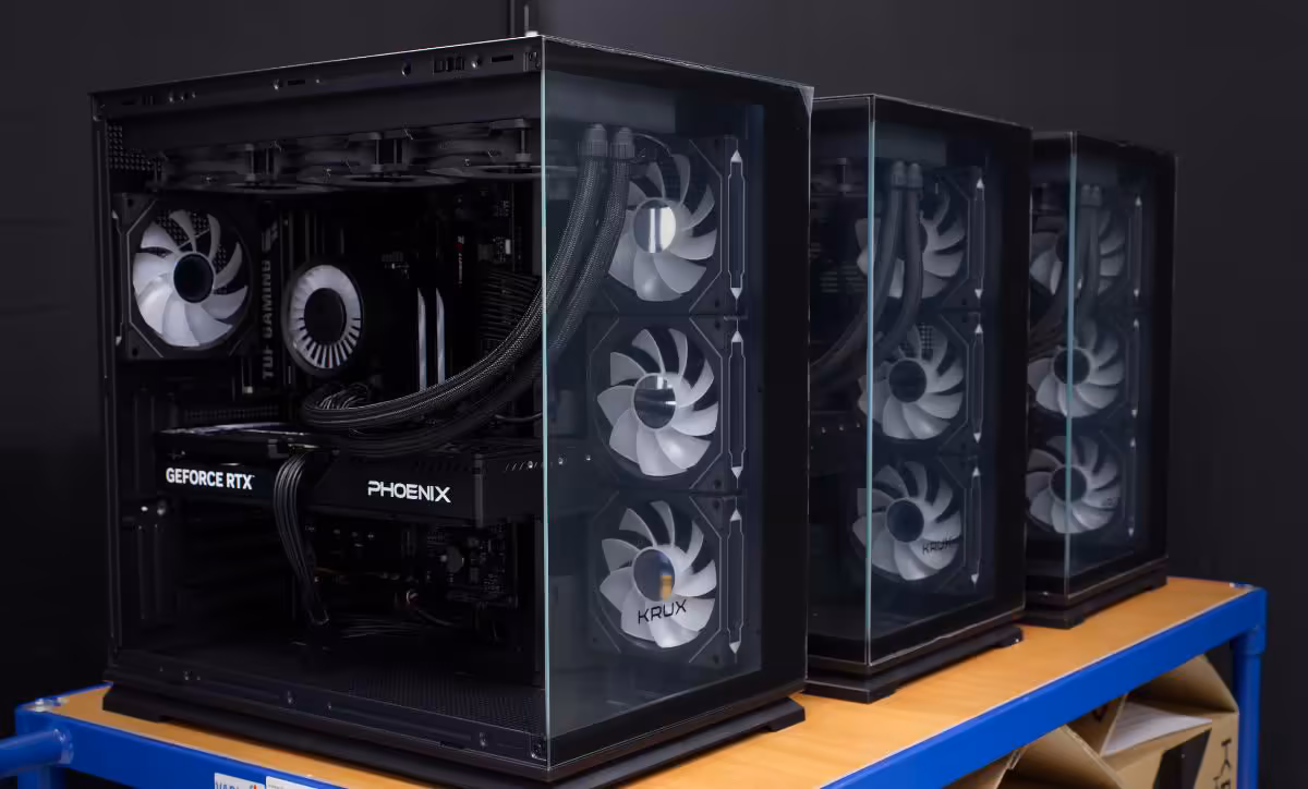 Trois PC gaming vitrés alignés, avec cartes GeForce RTX Phoenix et ventilateurs arrière visibles