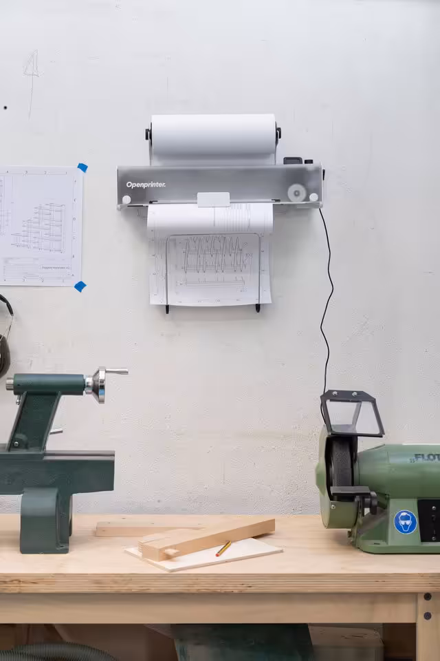 Open Printer : une imprimante open source, réparable et sans DRM bientôt sur CrowdSupply 3 Imprimante OpenPrinter fixée au mur au-dessus d’un établi, avec outils d’atelier en arrière-plan.