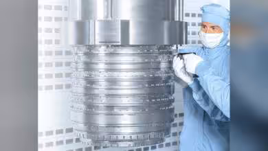 Technicien en salle blanche inspectant un scanner DUV immersion avec grand cylindre métallique industriel