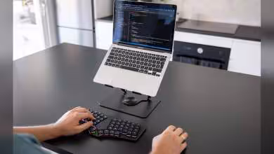 Dygma Sonsei utilisé avec un MacBook sur support, en situation de frappe sur bureau