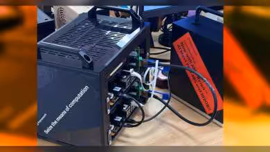 Boîtier informatique noir avec câbles connectés, éclairage professionnel fond neutre
