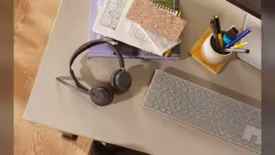 Casque Jabra Evolve3 sur bureau avec clavier, carnet et accessoires de travail