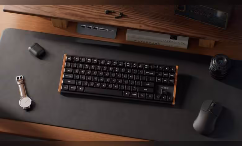 Keychron K1 Ultra 8K : le TKL low-profile en bois et 8 kHz arrive à 109,99 $ 1 Clavier Keychron K1 Ultra 8K TKL low-profile avec accents bois, posé sur un bureau avec souris et montre.
