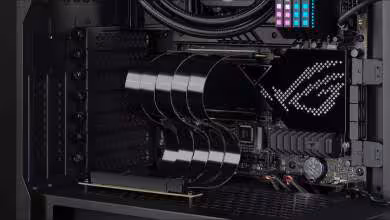 Intérieur d'un PC avec riser et GPU ASUS ROG éclairage RGB fond sombre contrasté