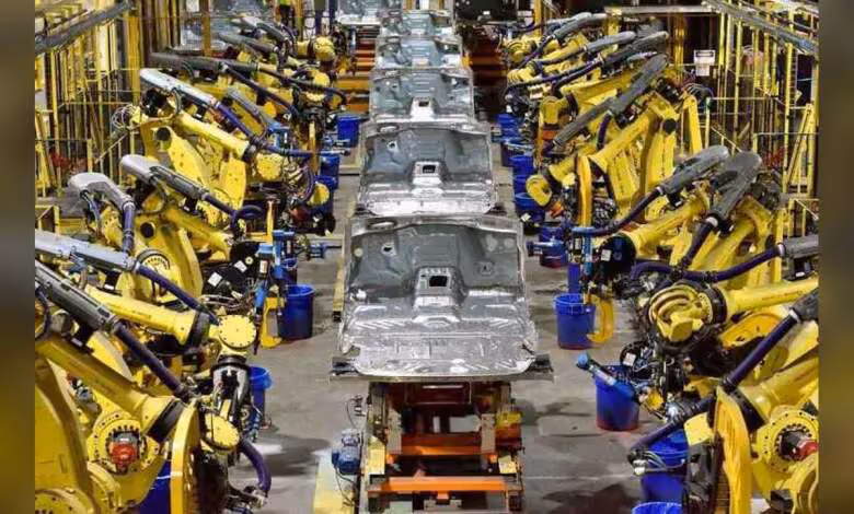 Micron Ford : un accord long terme pour sécuriser la mémoire des véhicules de nouvelle génération 1 Chaîne d’assemblage automobile Ford avec nombreux bras robots jaunes autour d’une carrosserie métallique blanche