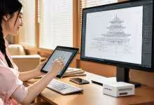 Femme dessinant sur tablette graphique avec mini PC blanc sur bureau, écran montrant un croquis architectural