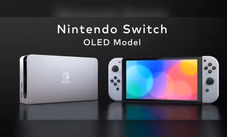 Switch 2 : batterie remplaçable en Europe dès 2025, fin des ventes Switch en 2027 1 Console Nintendo Switch modèle OLED avec manettes Joy-Con grises sur fond noir.