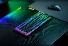 Clavier gaming compact RGB sur bureau avec souris, éclairage arc-en-ciel et design noir