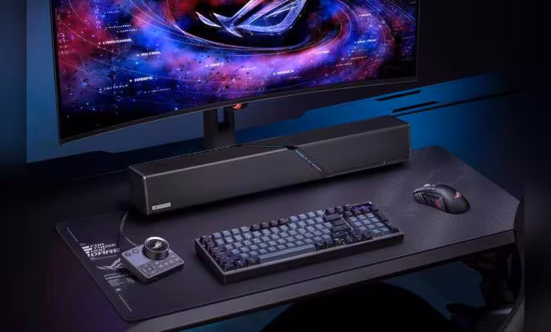 ROG Gjallar : ASUS lance une barre de son Dolby Atmos 2.1.2 pensée pour le jeu 1 Barre de son ASUS ROG Gjallar sur bureau gaming avec clavier, souris et écran