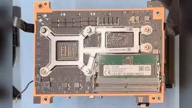 Composant informatique interne avec module RAM installé et connecteurs visibles sur circuit imprimé.