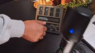Personne utilisant un Stream Deck avec boutons configurables et molettes, vue produit réelle sur bureau.