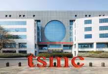 Façade moderne du siège TSMC avec logo rouge devant un bâtiment de bureaux industriel et vitré