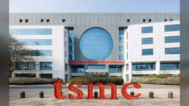 Façade moderne du siège TSMC avec logo rouge devant un bâtiment de bureaux industriel et vitré