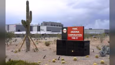 Enseigne TSMC Arizona Corporation Fab 21 devant le site industriel, avec cactus et bâtiments en arrière-plan