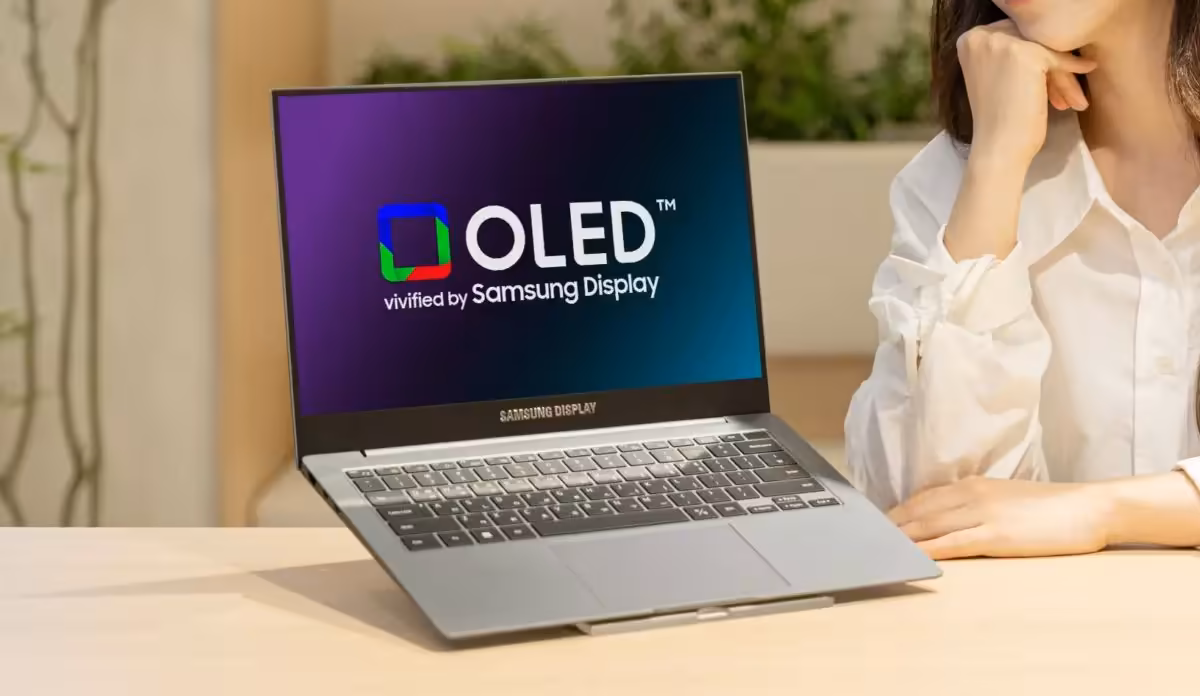 OLED tandem Samsung : les premiers PC portables True Black 1400 montent à 1 600 nits 2 Ordinateur portable Samsung OLED sur table, écran lumineux fond neutre.