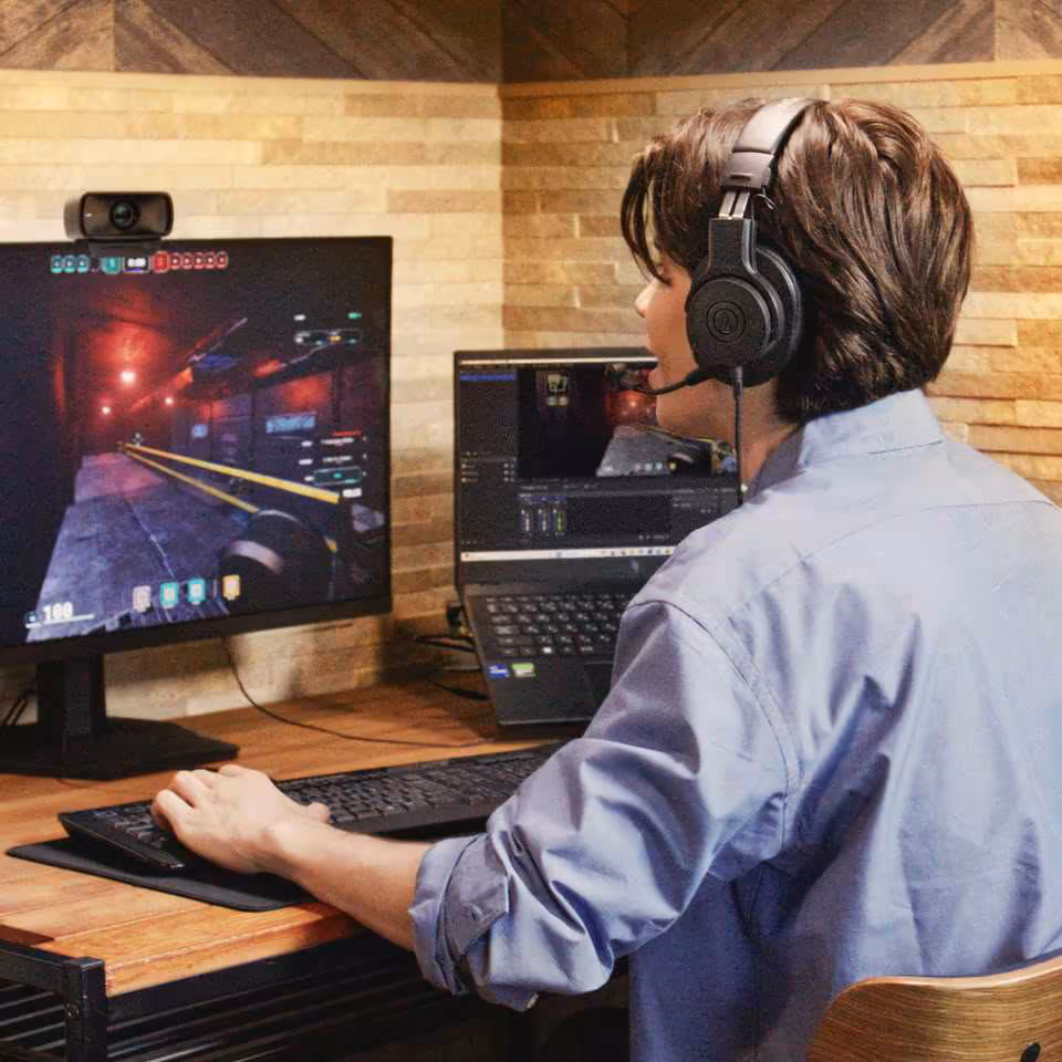 ATH-M20xSTS : Audio-Technica lance un casque streaming avec micro cardioïde à 119 $ 4 Personne portant un casque Audio-Technica en usage streaming ou gaming devant écran et laptop