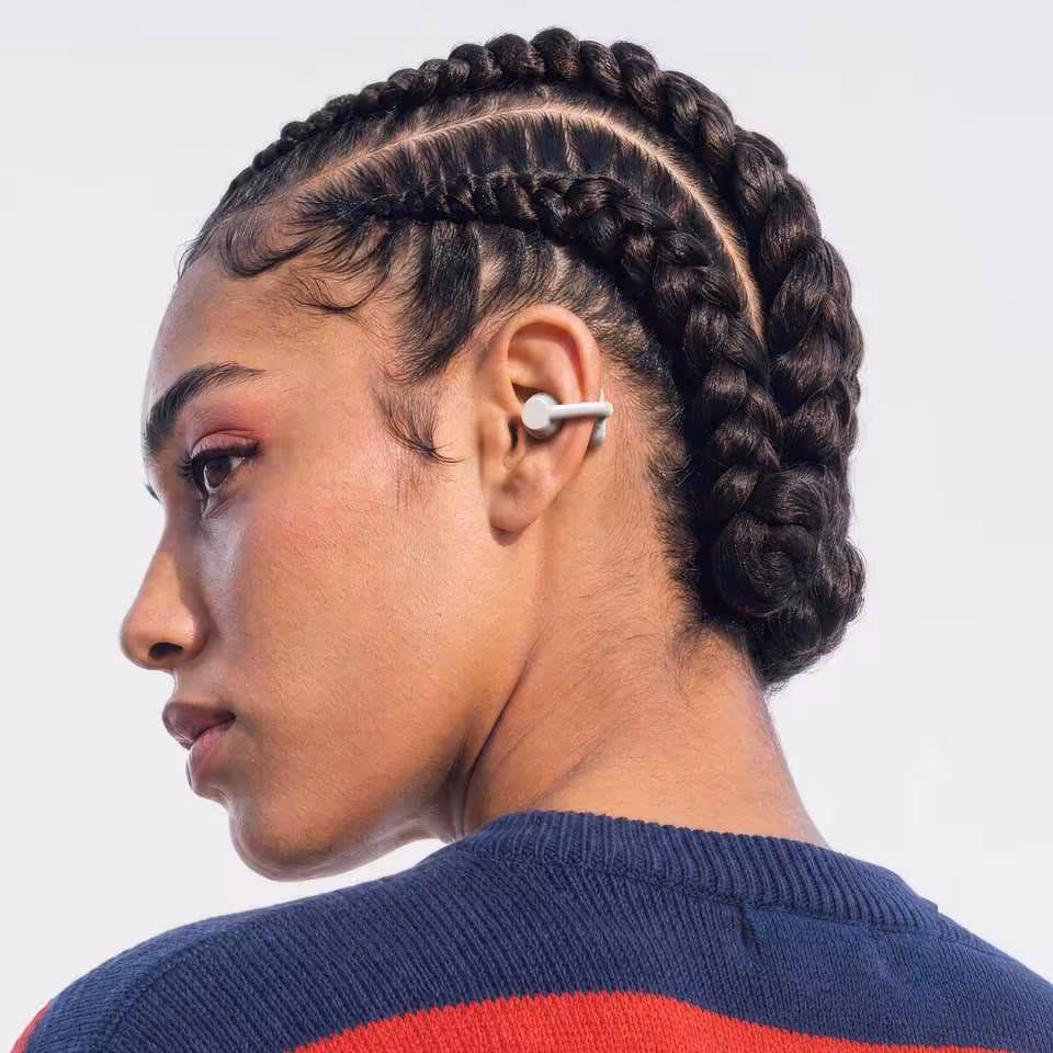 Femme portant un écouteur open-ear CMF Clip Pro Nothing blanc à l’oreille