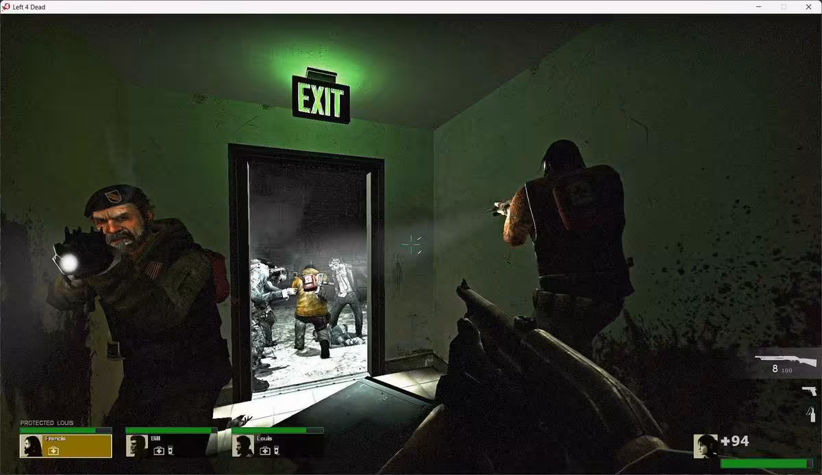 Capture Left 4 Dead avec trois survivants armés dans un couloir sombre, panneau EXIT visible