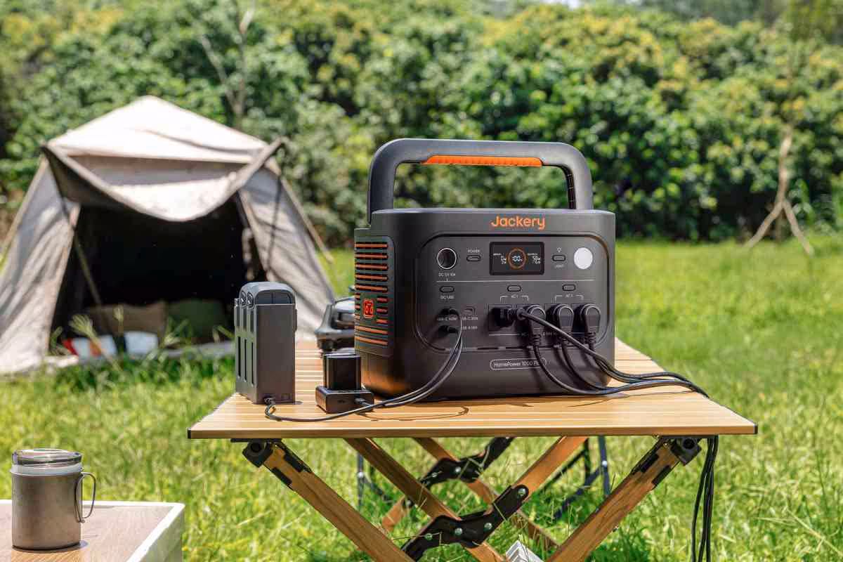 Jackery HomePower 1000 Plus V2 : une station 1 024 Wh extensible à 11 kWh 2 Jackery HomePower 1000 Plus V2 sur table de camping, tente en arrière-plan et batterie externe connectée