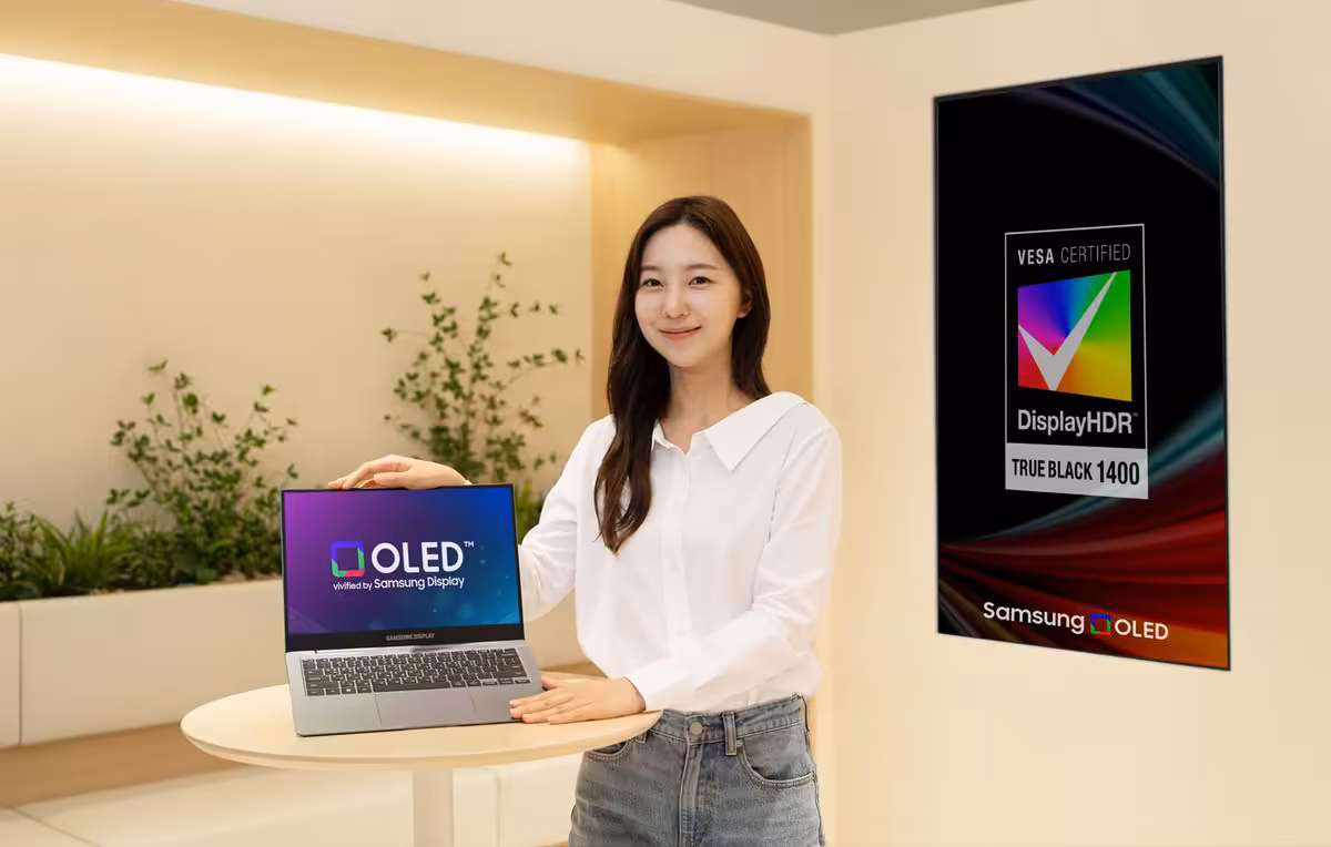 Femme présentant un ordinateur portable OLED Samsung Display, avec panneau VESA DisplayHDR True Black 1400