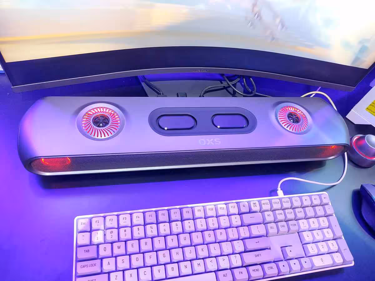 OXS Thunder Duo et Pro Max à la Gamescom 2026, l’Atmos PC passe par un haut-parleur de cou 6 Barre de son OXS Thunder Duo posée sous écran, avec deux haut-parleurs et clavier devant