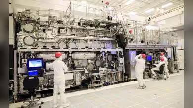 Machine lithographique EUV High-NA ASML dans une salle blanche Samsung avec techniciens en combinaison protectrice