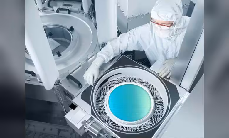 Lam Research investira plus de 3 milliards de dollars dans ses labos R&D mondiaux 1 Technicien en salle blanche manipulant un wafer de silicium dans un équipement de fabrication de semi-conducteurs