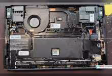 Intérieur d'un appareil Lenovo démontrant composants électroniques avec étiquettes Lenovo et ventilateur visible.