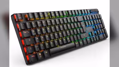Clavier Sharkoon PureWriter W100 noir avec rétroéclairage RGB multicolore, vue trois-quarts sur fond blanc