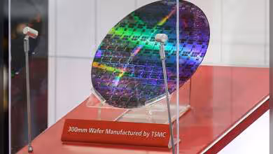 Wafer 300 mm TSMC exposée sous vitrine, reflet irisé, plaque rouge « 300mm Wafer Manufactured by TSMC »