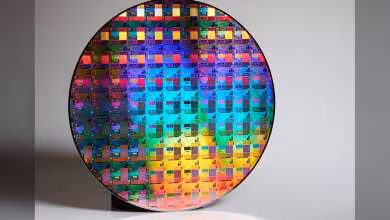 Wafer de silicium TSMC multicolore avec motifs de puces, illustrant une fabrication de semi-conducteurs 2 nm