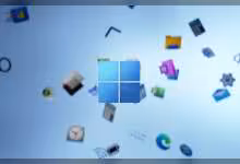 Logo Windows 11 bleu au centre, avec icônes d’applications flottantes sur fond clair abstrait