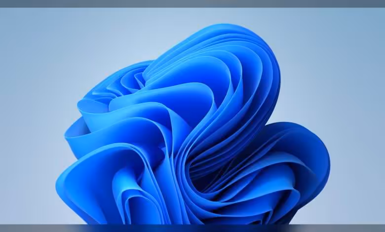 Windows 11 prépare des correctifs mémoire et un Explorateur de fichiers plus fiable 1 Fond d’écran Windows 11 bleu abstrait avec rubans ondulés en forme de fleur, style minimaliste