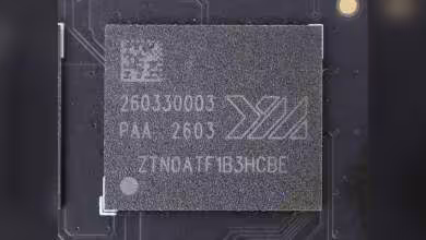 Puce mémoire NAND YMTC gravée 260330003, marquage X3, vue rapprochée sur circuit imprimé noir