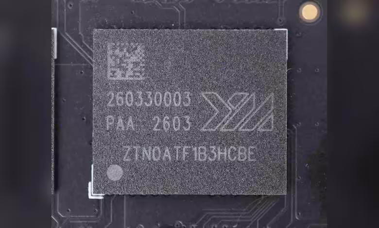 YMTC vise la première place de la NAND mondiale devant Samsung et SK hynix d’ici 2027 1 Puce mémoire NAND YMTC gravée 260330003, marquage X3, vue rapprochée sur circuit imprimé noir