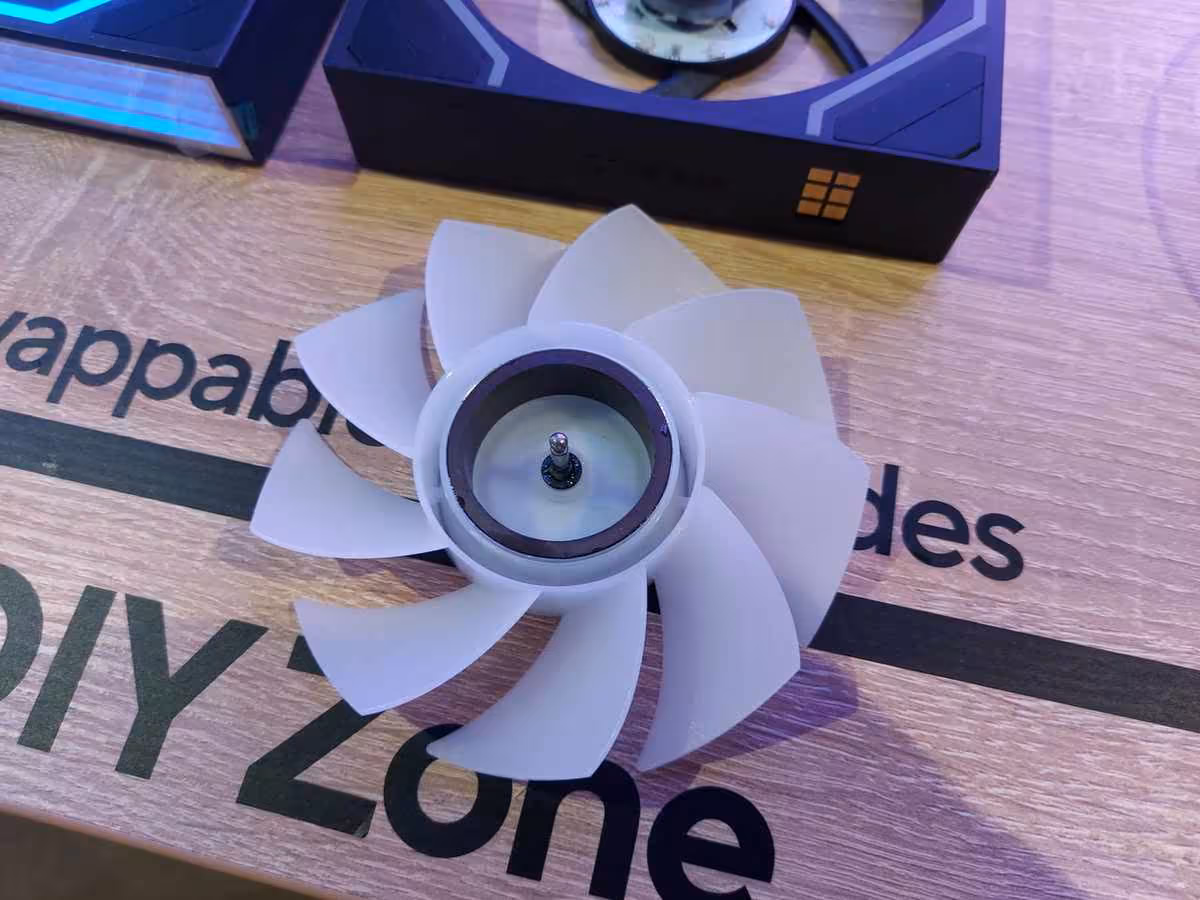 Thermaltake Gamescom 2026 : CAPO X, Stage 450 TG et alimentations DockPower 11 Pales de ventilateur blanches Thermaltake démonstration sur plateau Wood Zone.