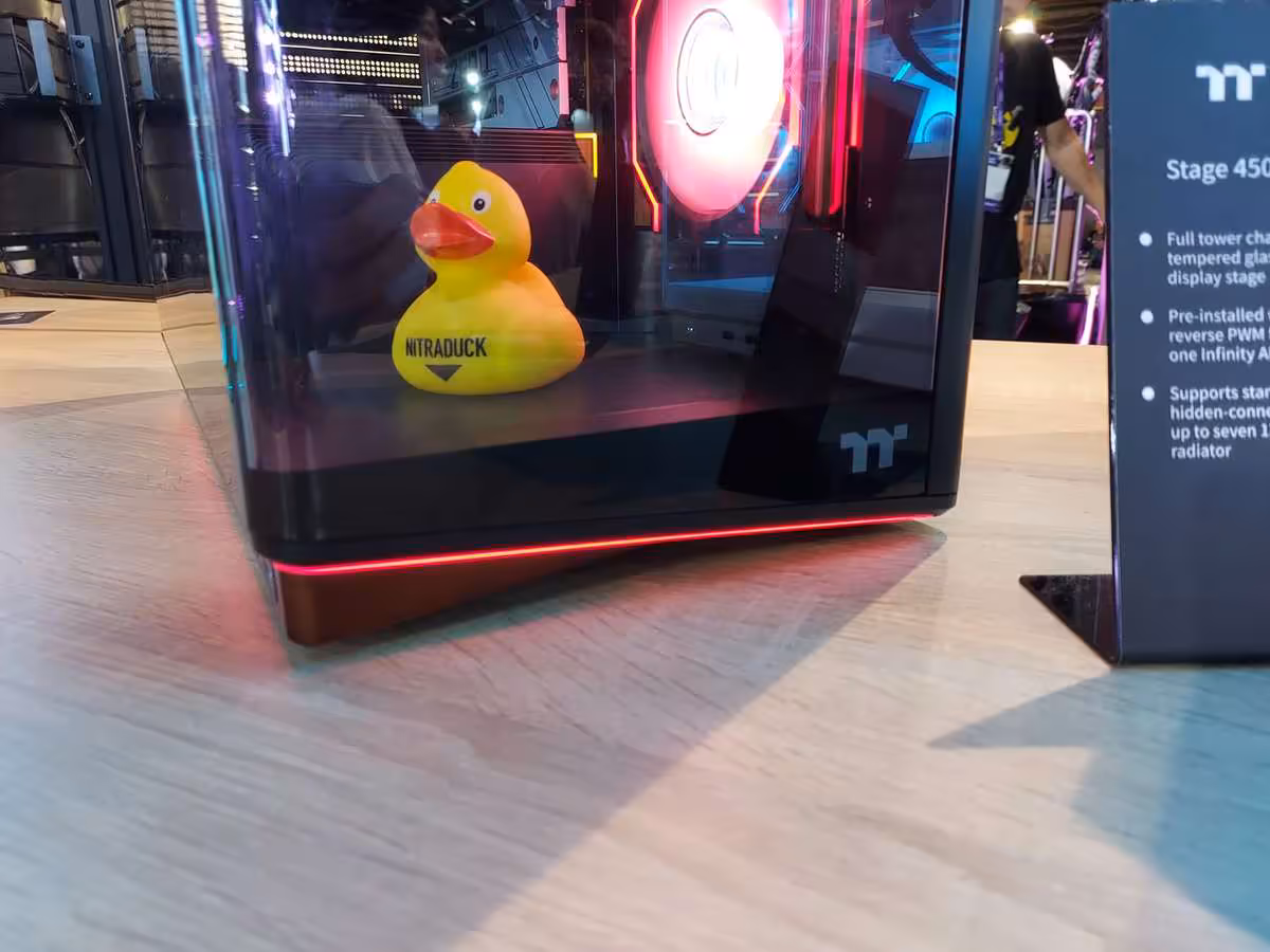 Thermaltake Gamescom 2026 : CAPO X, Stage 450 TG et alimentations DockPower 18 Gros plan du boîtier Stage 450 TG, canard jaune et bande LED rouge en bas.