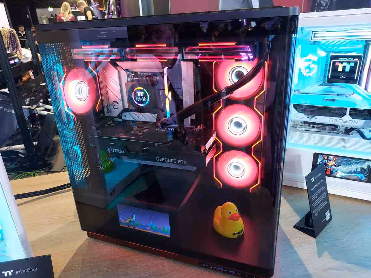 Thermaltake Gamescom 2026 : CAPO X, Stage 450 TG et alimentations DockPower 19 Boîtier Thermaltake noir vitré avec carte MSI GeForce RTX, ventilateurs RGB rouges et canard jaune.