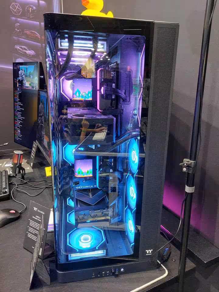 Thermaltake Gamescom 2026 : CAPO X, Stage 450 TG et alimentations DockPower 3 Boîtier Thermaltake noir vitré, configuration RGB bleue, trois ventilateurs frontaux et écran interne.