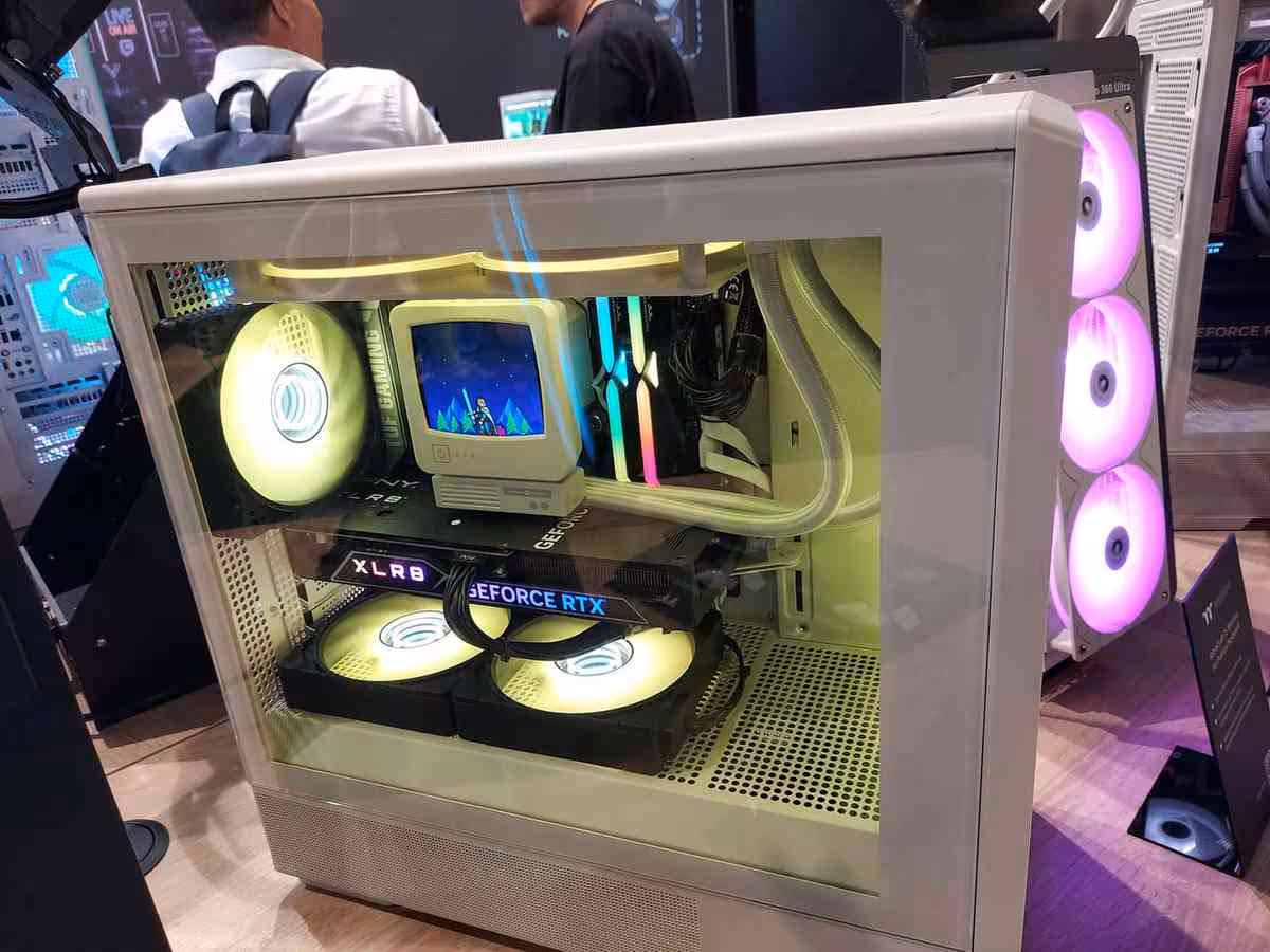 Thermaltake Gamescom 2026 : CAPO X, Stage 450 TG et alimentations DockPower 8 Boîtier Thermaltake blanc rétro, carte GeForce RTX et éclairage RGB jaune et rose.