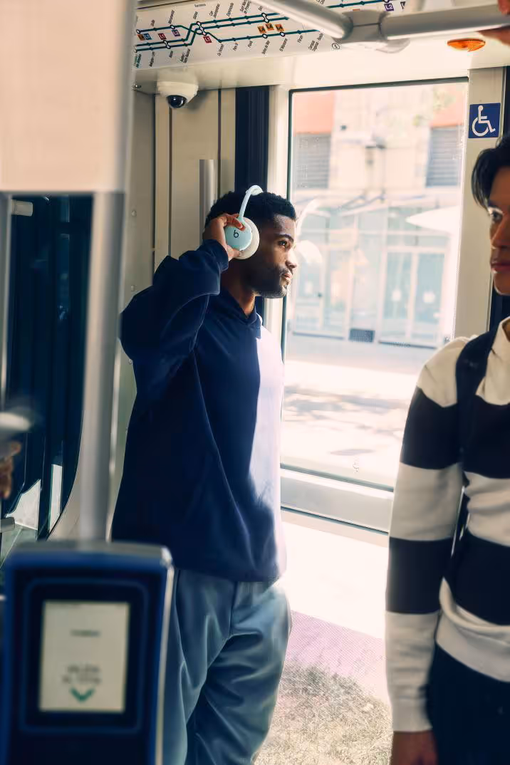 Beats 360 : le casque modulable mise sur l’ANC, le confort et 32 heures d’autonomie 8 Homme portant un casque Beats 360 blanc dans les transports en commun